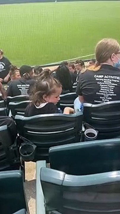 Little girl sticks her hand in random cup of soda at baseball game