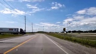 Oblivious truck driver forces car onto the shoulder of the road