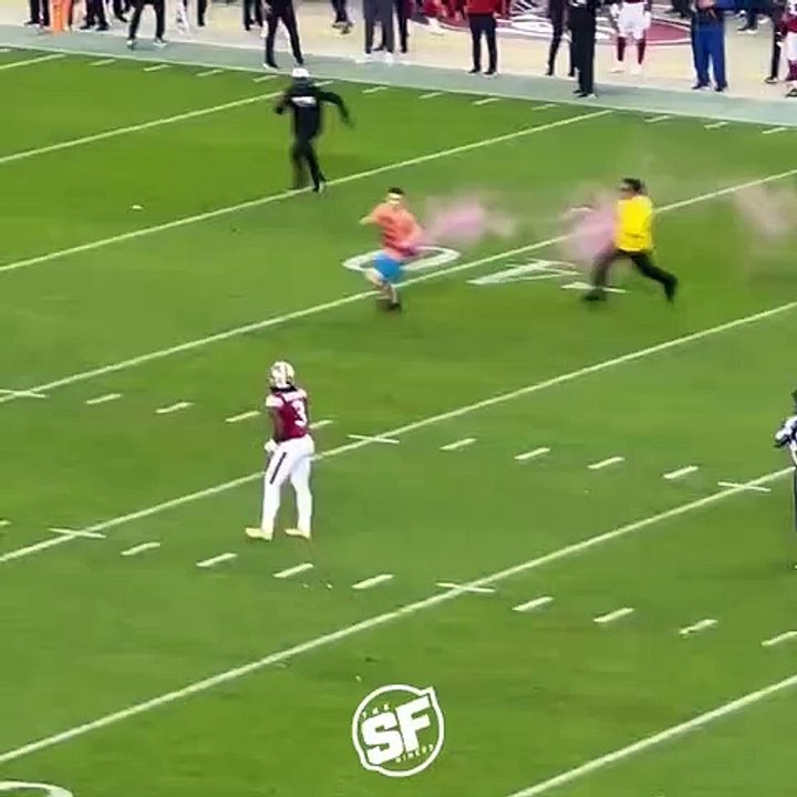 Un joueur de foot US s'occupe d'un activiste qui vient perturber un match
