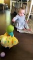 Baby utterly shocked at toy hen laying eggs