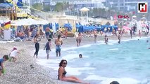 Antalya'da nemden bunalan Konyaaltı Sahili’ne akın etti
