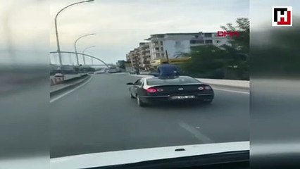 Otomobilin üstüne oturarak yolculuk yaptı