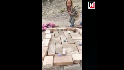 Tuğladan yapılmış masada bilardo oynayan çocuklar