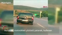 Trafikte tepki çeken olay! Motosikleti yüzüstü yatarak kullandı