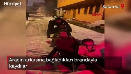 Aracın arkasına bağladıkları brandayla kayıp eğlendiler