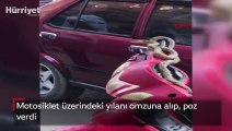 Motosiklet üzerindeki yılanı omzuna alıp, poz verdi
