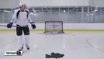 Drone'un üzerindeki hedefleri vurmaya çalışan buz hokeyi oyuncusu