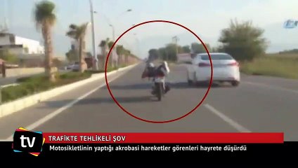 Trafikte tehlikeli şov, motorun üzerine uzandı