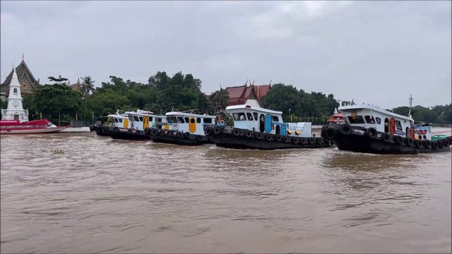 5 tugboats pulling a huge barge at the Chao Phraya River Koh Kret island Thailand