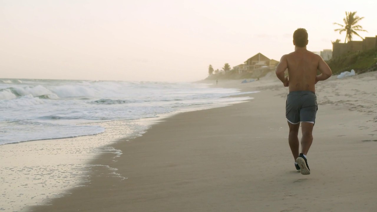 Man Jogging On The Beach.