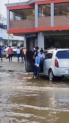 Un homme porte une femme à une voiture dans une rue inondée - Buzz Buddy