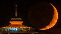 Crescent moon sets behind Seattle's Space Needle