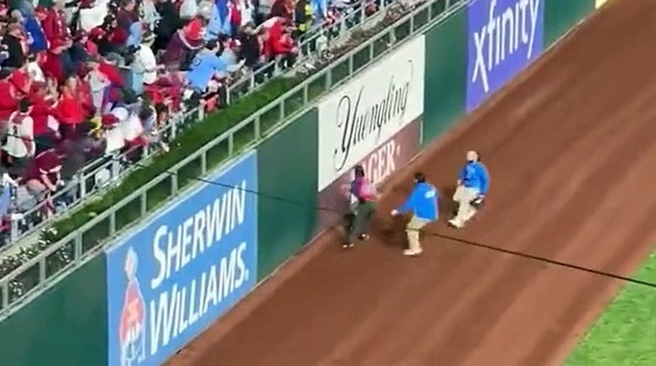 World Series field invader embarrassingly struggles to climb outfield wall as his attempt to escape security FAILS - and his humiliation continues with fans chanting 'a**hole'