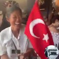 Tayland'da elinde Türk bayrağı ile İzmir marşı söyleyen Taylandlı kadın