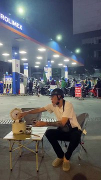 Thanh niên tranh thủ làm bát cơm nóng trong lúc xếp hàng chờ đổ xăng