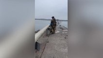 Ukrainian soldiers tie flag to partially collapsed Antonivskiy bridge in Kherson region