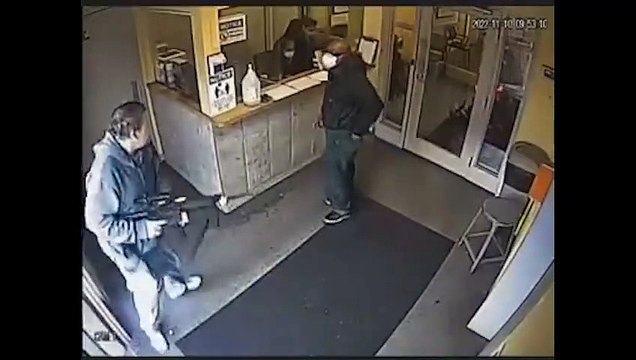 Un agent de sécurité repousse et maîtrise un homme armé d'un fusil qui veut faire un braquage