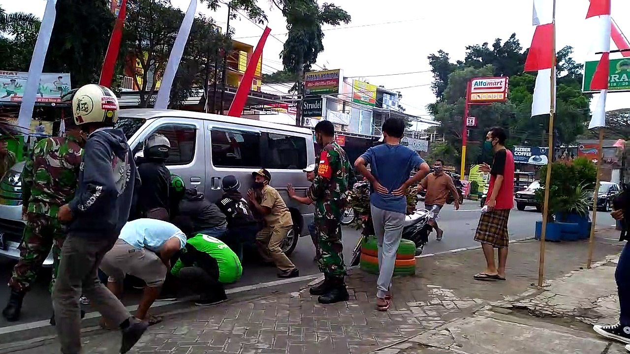 The woman is stressed getting under the car because her partner lives (setres di tinggal pasangan)