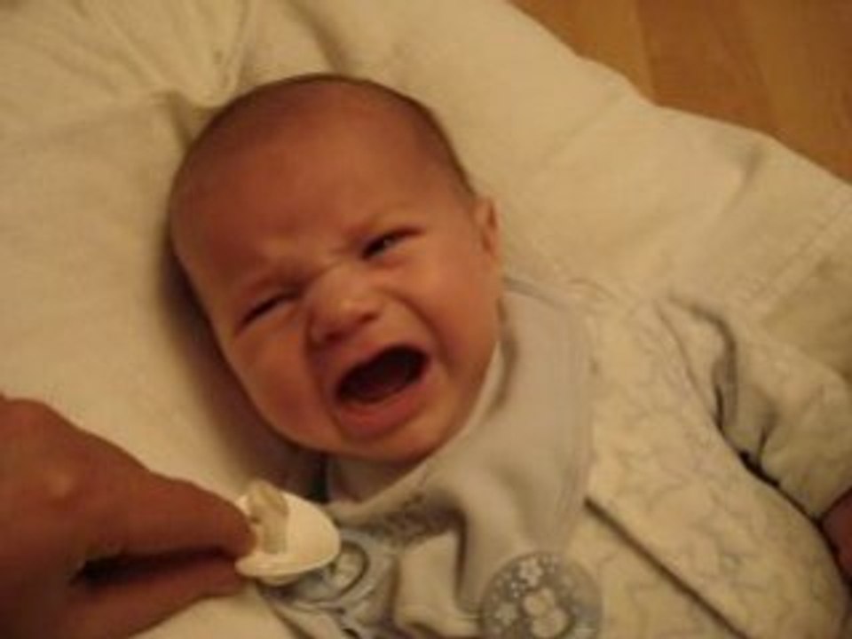 Antoine cherche à attraper sa sucette et y arrive