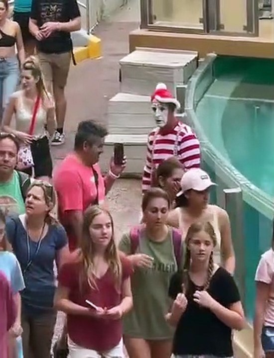 Un mime trolle un touriste qui passe devant lui en le filmant