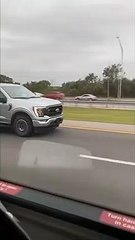 Une maman conduit avec son bébé sur les genoux et en faisant des selfies