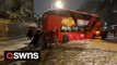 Londoners band together to move bus that got stuck across road during intense snowfall in the capital