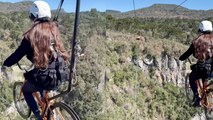 Woman embraces her adventurous side by riding a bicycle on a zip line 150 meters above the ground!