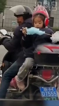 Ngồi sau xe, cô bé không quên chia sẻ miếng kẹo bông gòn cho cha: Sau lưng cha là bình yên