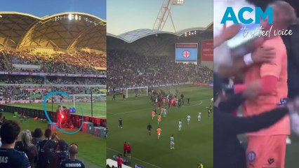 Crowd footage of soccer fans storming the pitch at the Melbourne derby