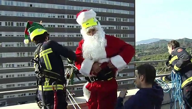 Papa Noel desciende por la fachada del hospital Germans Trias para repartir regalos a niños ingresados