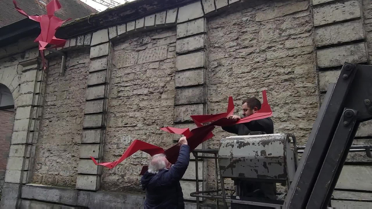 Trois pantins grimpeurs sur un mur de l’Hôpital Notre-Dame à Tournai