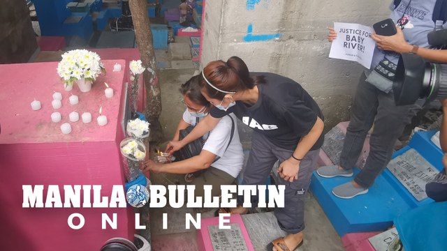 Reina Mae Nasino offers prayers and lit candles for Baby River at Manila North Cemetery