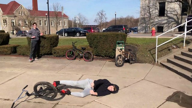 BMX rider jumps stairs then falls back and lands on his head