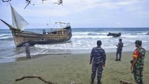 Rohingya refugees await emergency services after landing on Indonesia beach