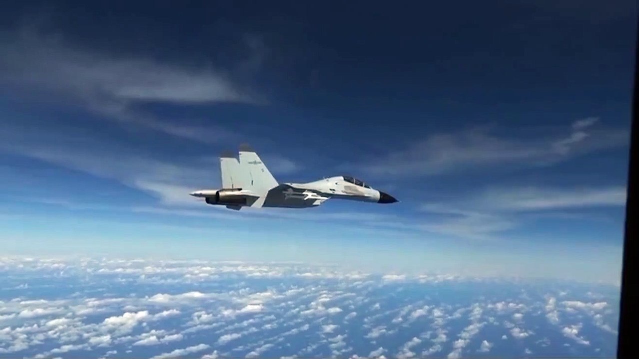 Un avion J-11 de l'armée Chinoise vole tout prêt d'un avion RC-135 américain