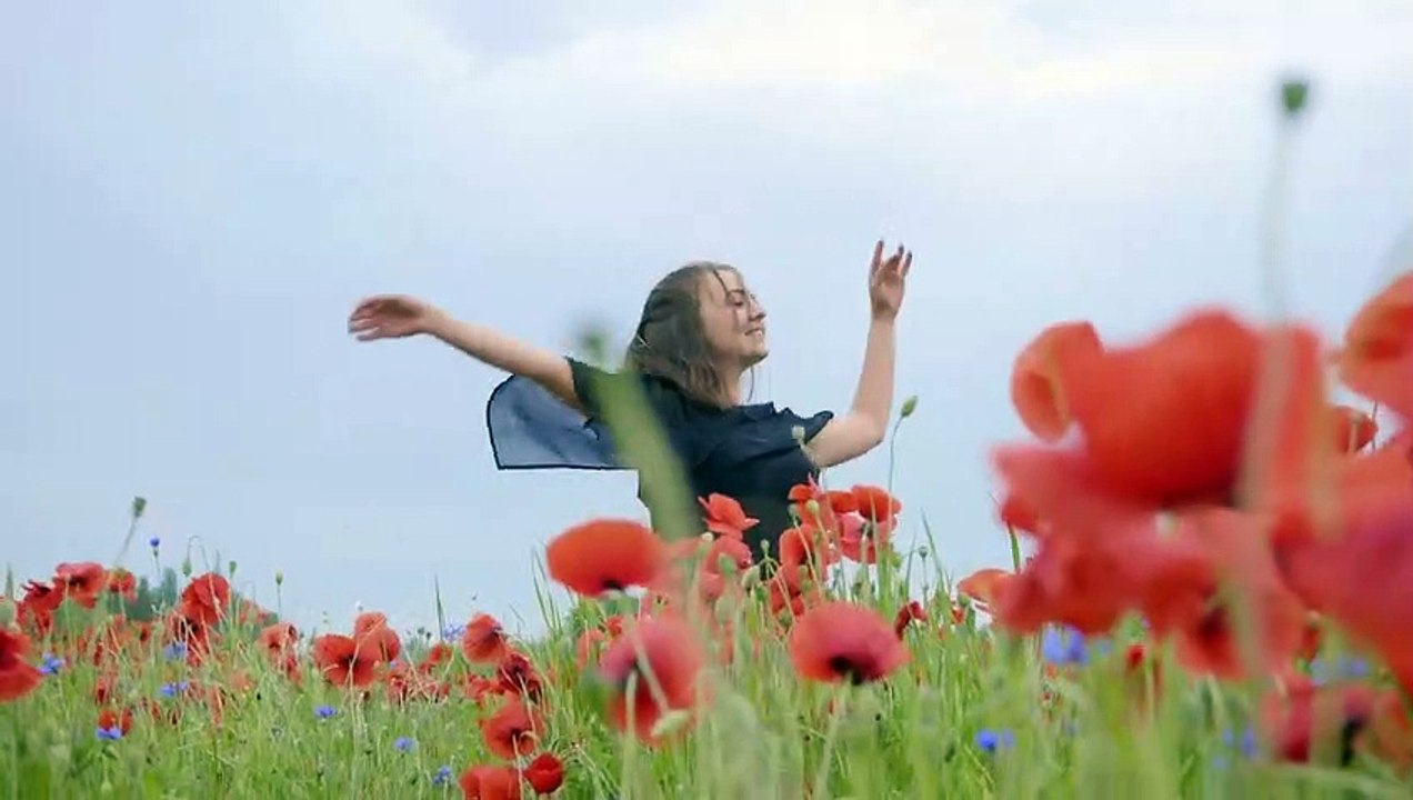 mixkit-girl-dancing-happily-in-a-field-of-flowers-4702-medium