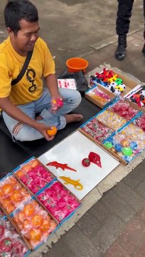 Des enfants sont émerveillés par le spectacle d'un vendeur ambulant