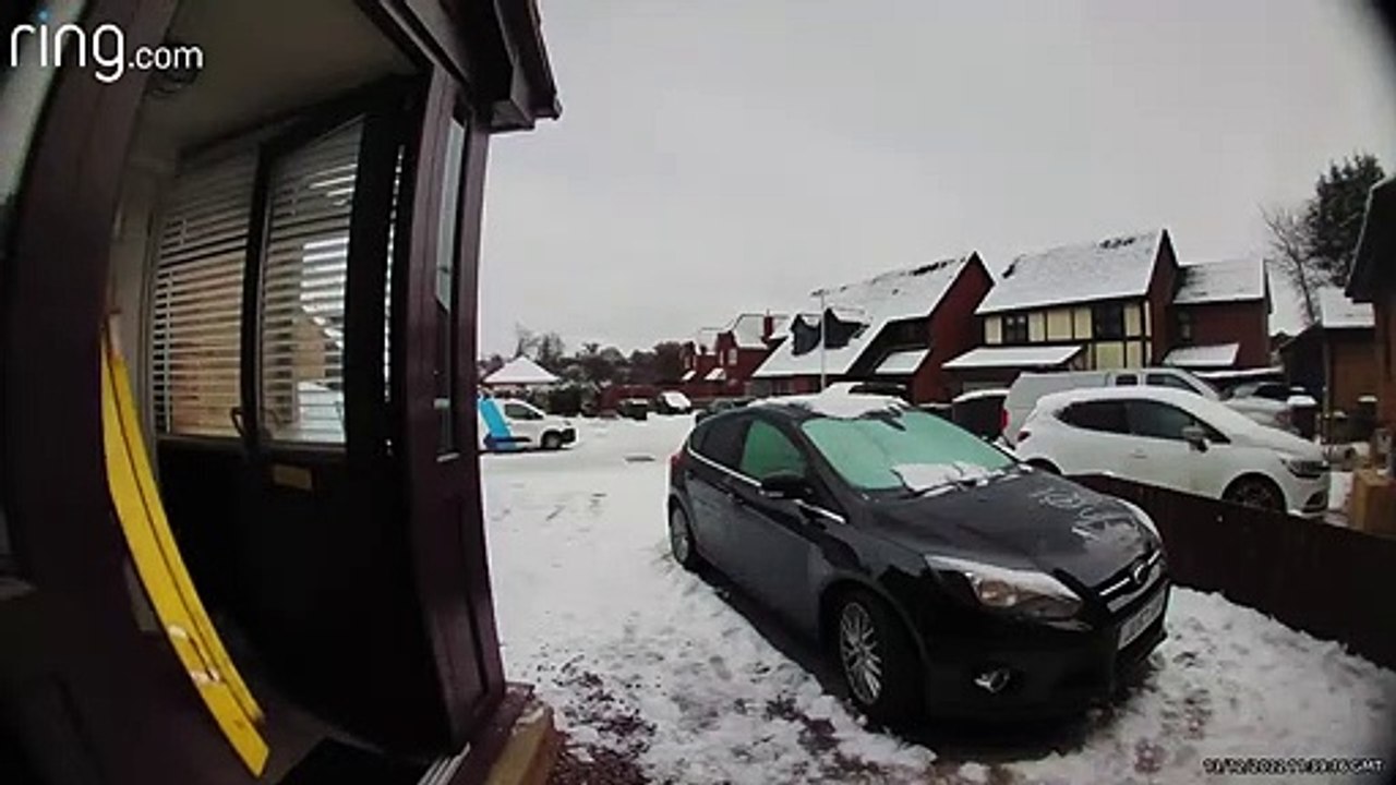 Un homme glisse sur la glace en portant une éch...