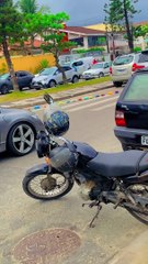 Train of Toy Cars Pulled Down the Street by Cyclist