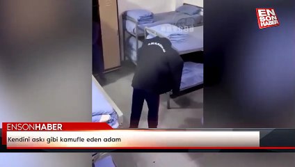 Kendini askı gibi kamufle eden adam
