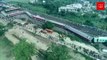 Drone footage shows a stretch of derailed train carriages and crowds at the crash site in India