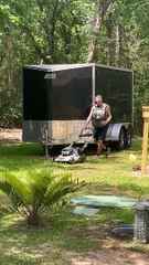 Man Mows Lawn While Carrying Cat in Backpack