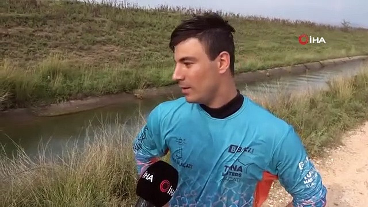 Surfer devant une caméra avec un tracteur dans un canal d'irrigation