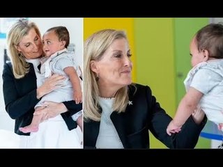 Rayonnante, Sophie, duchesse d'Édimbourg, regarde avec adoration bébé lors d'une visite à l'hospice