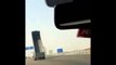 Un camion avec la remorque levée passe sous un pont sur l'autoroute