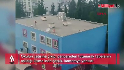 Okul çatısından pencerelere inen çocuk kamerada