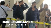 Passengers arriving at NAIA terminals are forced to remove glasses and caps upon undergoing thermal scanners