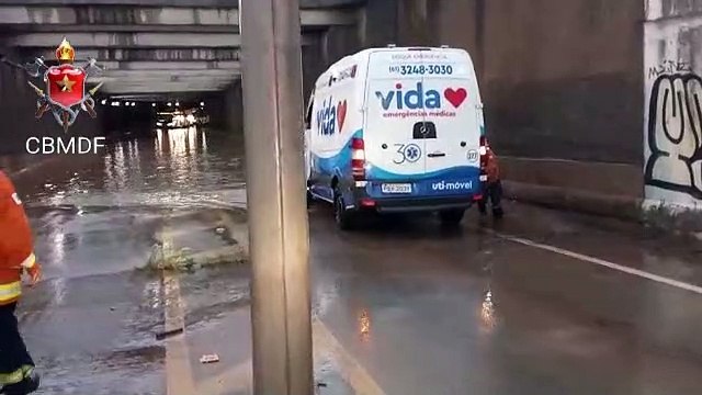 Bombeiros e policiais empurrando ambulância que falhou em viaduto alagado do Aeroporto