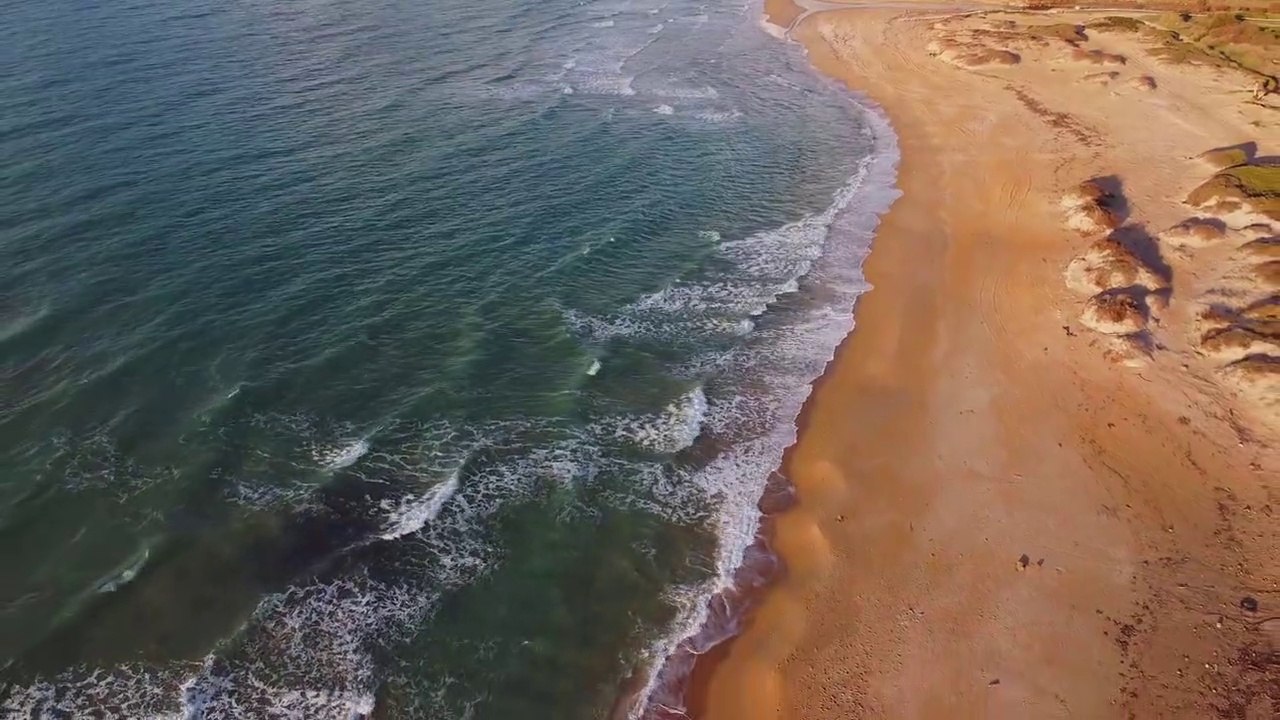 Waves kissing the long Shoreline ofA Beach