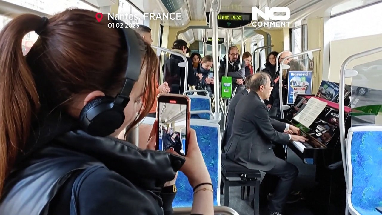 Deux musiciens installent leur piano dans un tramway pour un concert de musique classique